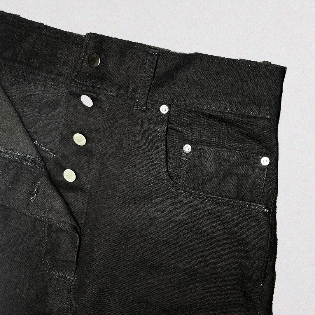 Close-up of black jeans with a pocket on a light gray background