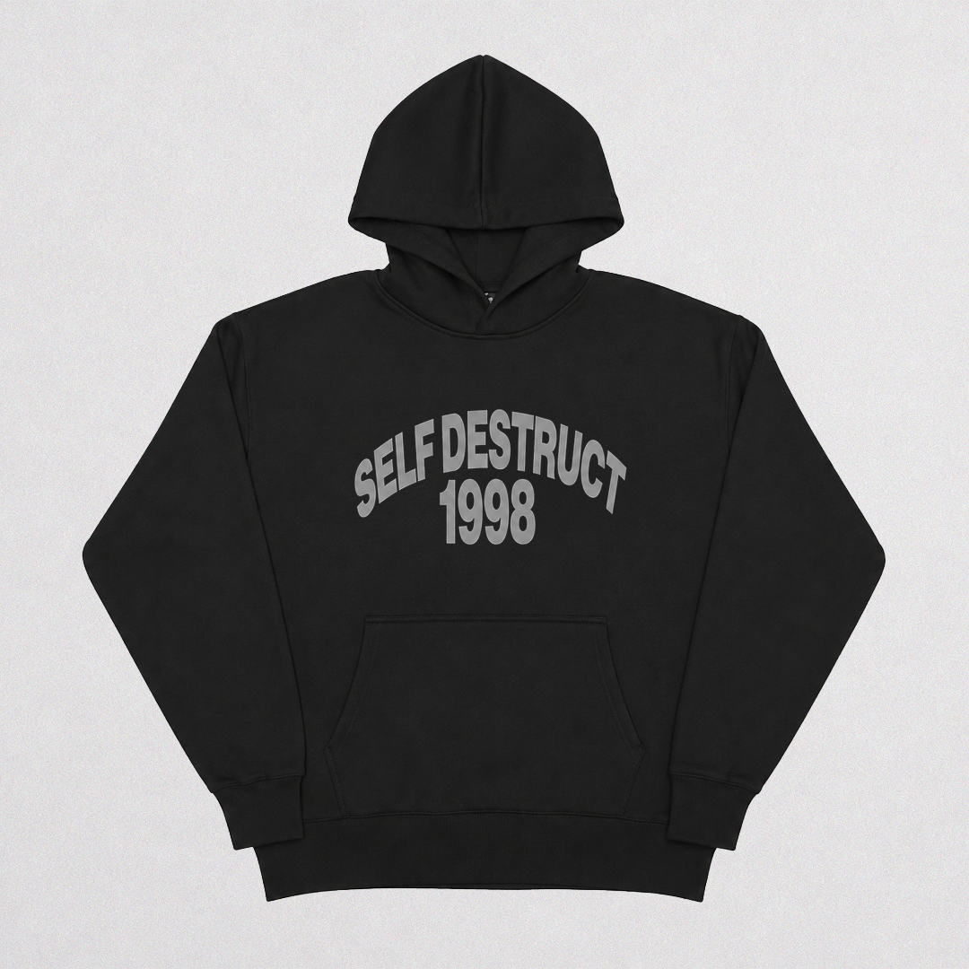 A black pullover hoodie with 'SELF DESTRUCT 1998' printed in gray arched text across the chest, displayed flat against a light gray background.
