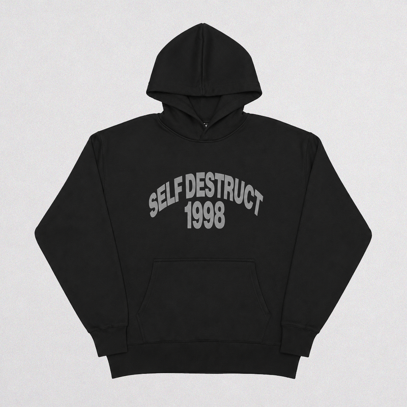 A black pullover hoodie with 'SELF DESTRUCT 1998' printed in gray arched text across the chest, displayed flat against a light gray background.